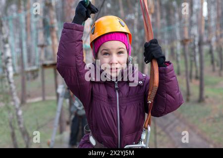 Die kleine Klettererin ist bereit, den Seilgarten zu überqueren Stockfoto