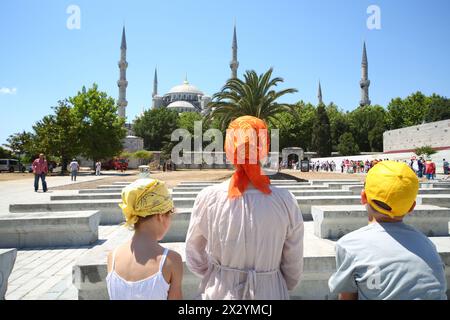 ISTANBUL – 3. JUL: Mutter, Sohn und Tochter gehen am 3. Juli 2012 in die Sultanahmet-Moschee vor dem Hagia Sophia Museum in Istanbul Stockfoto