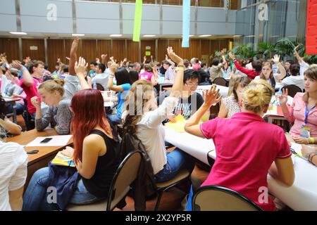 MOSKAU - 18. AUGUST: Jugendliche heben ihre Hände, um in der Jugendgesundheitsgruppe auf der Global Youth Voice - AIESEC International Congress 2012 in MGIMO zu antworten Stockfoto