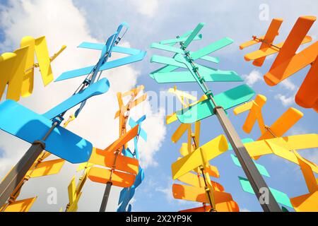 Set aus mehrfarbigen Flügeln und Schildern auf dem Hintergrund des blauen Himmels mit Wolken. Stockfoto