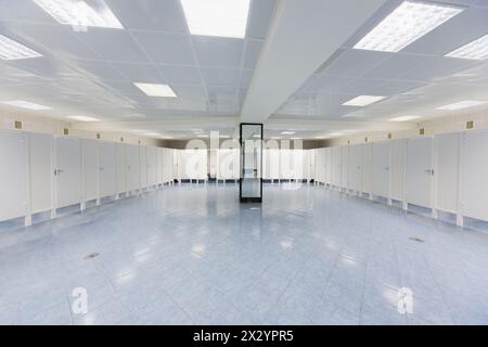 Leere moderne öffentliche Toilette mit einer Reihe von Toiletten und einem Spiegel Stockfoto