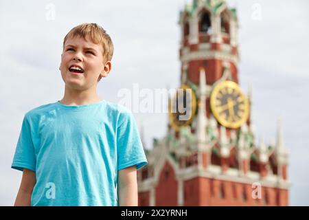 Porträt eines Jungen im blauen T-Shirt gegen den Spassky-Turm des Moskauer Kreml Stockfoto