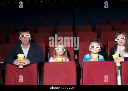 Eltern mit Sohn und Tochter in 3D-Brille mit Popcorn im Kino Stockfoto