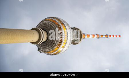 Der Berliner Fernsehturm steht hoch vor einem bewölkten Himmel und zeigt seine berühmte kugelförmige Aussichtsplattform. Berlin, Deutschland. Fotografie um 90 Grad gedreht. Stockfoto
