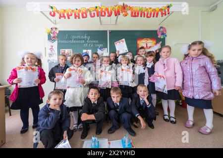 MOSKAU - 1. September 2012: Gekleidete Erstklässler mit Geschenken in den Händen in einem Klassenzimmer der Schule Nr. 1349 in Moskau, Russland. Stockfoto