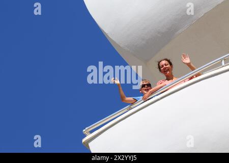 Glückliche Mutter mit Sohn, der auf dem Balkon des Wohnkomplexes steht Stockfoto