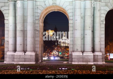 Blick auf die Straße Calle de Alcala durch den Arch Puerta de Alcala am Platz der Unabhängigkeit Spaniens bei Nacht in Madrid, Spanien. Stockfoto