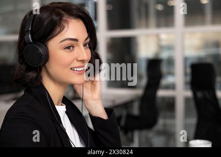 Professionelle Callcenter-Mitarbeiterin mit schnurlosem Headset Stockfoto