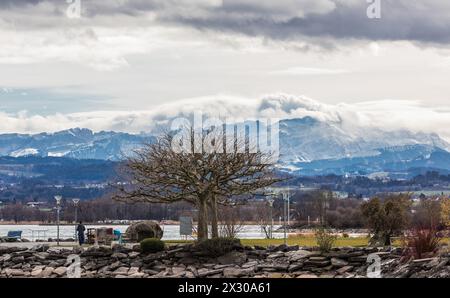 Romanshorn, Schweiz - 20. Februar 2022: In Richtung Schweizer Alpen sieht die Stimmung stürmisch aus. Dicke, graue Wolken ziehen Richtung Alpen. Stockfoto