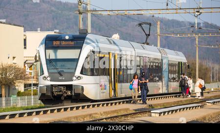 Embrach, Schweiz - 26. März 2022: Ein Thurbo Zug der Linie S41 hält am Bahnhof Embrach und fährt weiter in Richtung Winterthur. Noch gilt im Öffentlic Stockfoto