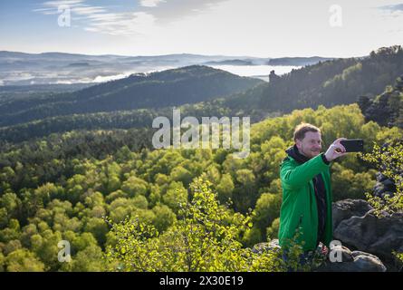 Gohrisch, Deutschland. April 2024. Michael Kretschmer (CDU), sächsischer Ministerpräsident, macht ein Selfie auf dem Tafelberg Gohrisch während einer Wanderung vor der Sächsischen Kabinettssitzung im Bezirk Sächsische Schweiz-Osterzgebirge. Robert Michael/dpa/Alamy Live News Stockfoto