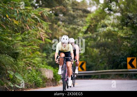 Gruppe junger asiatischer Profi-Radfahrer, die Radtraining auf der Landstraße fahren Stockfoto