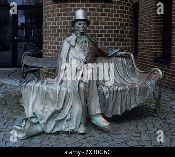 Glänzende Bronzestatue von H C Andersen in einem Hut auf einer Bank sitzend, Odense, Dänemark, 19. April 2024 Stockfoto