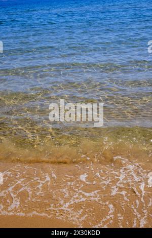 Ruhige Strandszene, wo klare, sanfte Wellen auf den goldenen Sand treffen Stockfoto