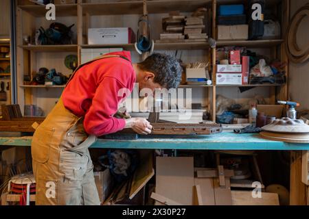 Fokussierte männliche Zimmerleute verwenden Meißelarbeiten mit handgefertigten Holzmöbeln in der Tischlerei. Stockfoto