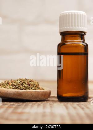 Nahaufnahme von ätherischem Thymianöl mit getrocknetem Thymian auf einem hölzernen Kochlöffel; DATUM NICHT ANGEGEBEN Stockfoto