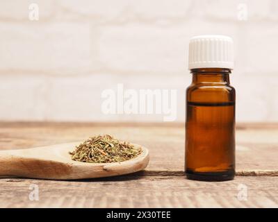 Nahaufnahme von ätherischem Thymianöl mit getrocknetem Thymian auf einem hölzernen Kochlöffel; DATUM NICHT ANGEGEBEN Stockfoto
