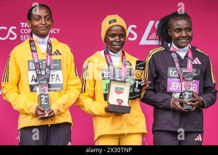 London Marathon 2024 Medaillenpräsentation, Gewinner der Elite-Rennen der Frauen, l-t-r Tigst Assefa, Peres Jepchirchir, Joyciline Jepkosgei, mit ihren Medaillen, Großbritannien Stockfoto
