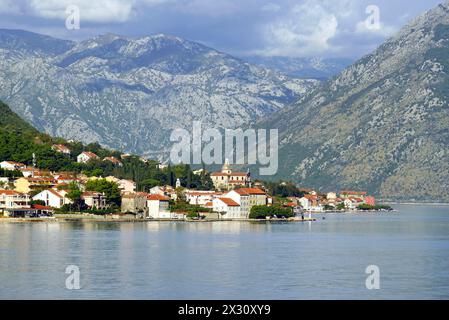 Das Zentrum der montenegrinischen Stadt Prcanj mit der Kirche der Jungfrau Maria vor dem Hintergrund der Berge - Blick von Dobrota Stockfoto