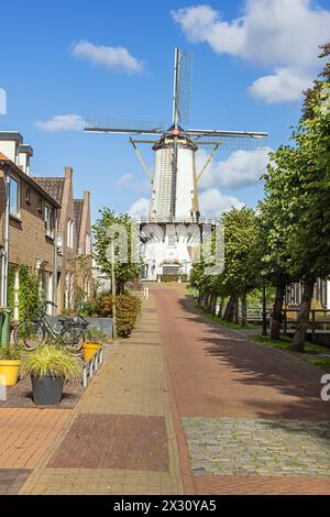 Eine sonnige Straße in Willemstad mit dem Orangmolen, der örtlichen Windmühle, im Hintergrund Stockfoto