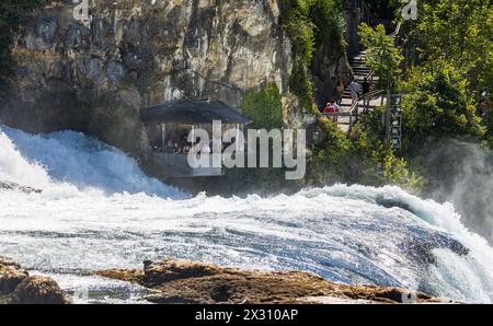 In einer Kanzel, welche auf dem Gebiet des Kanton Zürich liegt, beobachten Touristen den Rheinfall aus unmittelbarer Nähe. (Neuhausen am Rheinfall, SC Stockfoto