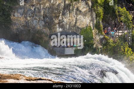 In einer Kanzel, welche auf dem Gebiet des Kanton Zürich liegt, beobachten Touristen den Rheinfall aus unmittelbarer Nähe. (Neuhausen am Rheinfall, SC Stockfoto