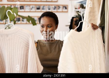 Einzelhandel, Shopping und schwarze Frau im Geschäft, Kunde und Wahl im Showroom oder in der Boutique. Kauf, Stoff und Secondhand-Kleidung für umweltfreundliche und Stockfoto