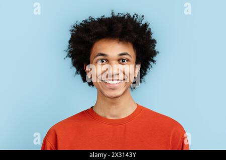 Lächelnder afroamerikaner in orangefarbenem Pullover Stockfoto