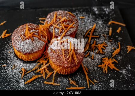 Karottenmuffins auf dunklem Hintergrund. Gesunde Karottenkuchen Muffins Stockfoto