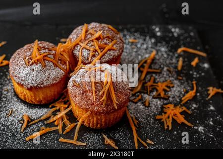 Karottenmuffins auf dunklem Hintergrund. Gesunde Karottenkuchen Muffins Stockfoto