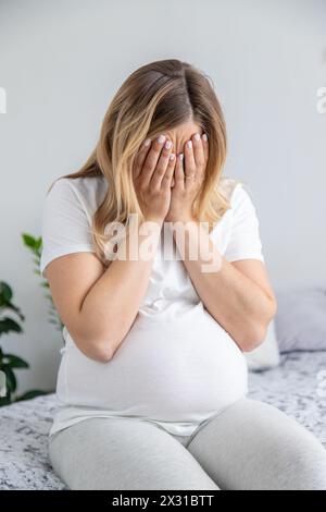 Schwangere Frau weint schlechte Laune. Selektiver Fokus. Startseite. Stockfoto