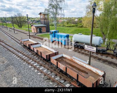 Hettstedt, Deutschland. April 2024. Mitglieder des Vereins Mansfelder Bergwerksbahn bereiten Güterwagen am Bahnhof Kupferkammerhütte vor. Die älteste in Betrieb befindliche Schmalspurbahn Deutschlands wird auch als dampfbetriebene Museumsbahn auf einem Teil des ehemals umfangreichen Bergbaubahnnetzes im Mansfeld betrieben. (Luftaufnahme mit Drohne) Credit: Jan Woitas/dpa/Alamy Live News Stockfoto