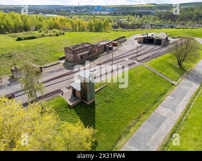 Hettstedt, Deutschland. April 2024. Mitglieder des Vereins Mansfelder Bergwerksbahn bereiten Güterwagen am Bahnhof Kupferkammerhütte vor. Die älteste in Betrieb befindliche Schmalspurbahn Deutschlands wird auch als dampfbetriebene Museumsbahn auf einem Teil des ehemals umfangreichen Bergbaubahnnetzes im Mansfeld betrieben. (Luftaufnahme mit Drohne) Credit: Jan Woitas/dpa/Alamy Live News Stockfoto