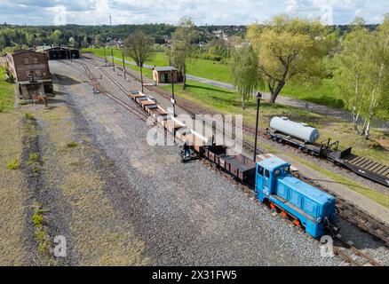 Hettstedt, Deutschland. April 2024. Mitglieder des Vereins Mansfelder Bergwerksbahn bereiten Güterwagen am Bahnhof Kupferkammerhütte vor. Die älteste in Betrieb befindliche Schmalspurbahn Deutschlands wird auch als dampfbetriebene Museumsbahn auf einem Teil des ehemals umfangreichen Bergbaubahnnetzes im Mansfeld betrieben. (Luftaufnahme mit Drohne) Credit: Jan Woitas/dpa/Alamy Live News Stockfoto