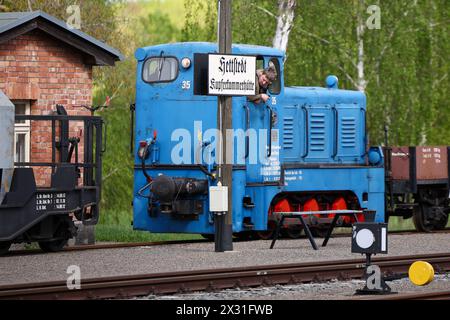 Hettstedt, Deutschland. April 2024. Ein Mitglied des Vereins Mansfelder Bergwerksbahn rangiert Güterwagen mit Diesellokomotive am Bahnhof Kupferkammerhütte. Die älteste in Betrieb befindliche Schmalspurbahn Deutschlands wird auch als dampfbetriebene Museumsbahn auf einem Teil des ehemals umfangreichen Bergbaubahnnetzes im Mansfeld betrieben. Quelle: Jan Woitas/dpa/Alamy Live News Stockfoto