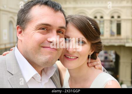 Porträt eines lächelnden frisch verheirateten Paares, das sich umarmt Stockfoto