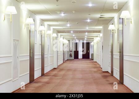 Geräumiger heller Flur mit vielen Türen, die in Hotelzimmer führen. Stockfoto