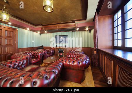 Luxuriöses englisches Zigarrenzimmer mit Ledersesseln und Kamin. Stockfoto