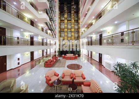 Atrium mit Sesseln, Sofas und Aufzügen in einem großen, modernen Hotel. Stockfoto