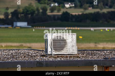 Eine Klimanlage, ältere Modelle, steht auf einem Dach eines Gebäudes. (Oberglatt, Schweiz, 29.08.2022) Stockfoto