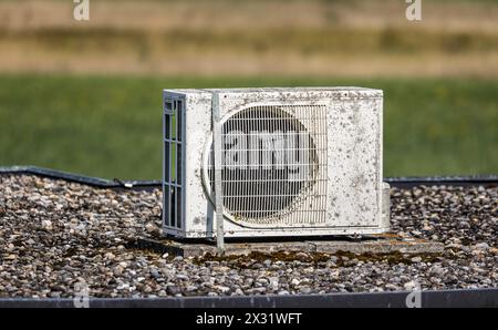 Eine Klimanlage, ältere Modelle, steht auf einem Dach eines Gebäudes. (Oberglatt, Schweiz, 29.08.2022) Stockfoto