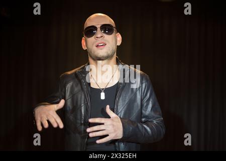 Ein Mann in einer Lederjacke mit einer Sonnenbrille, die mit den Händen Gesten macht Stockfoto