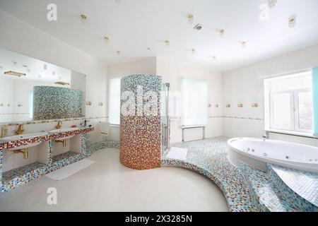 Zwei Waschbecken und Jacuzzi mit Treppen im geräumigen weißen Badezimmer. Stockfoto