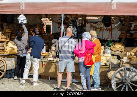 Moncalieri, Piemont, Italien - 20. April 2024: Kunden vor einem Marktstand, der handwerkliche Käsesorten und Wurstwaren verkauft. Stockfoto