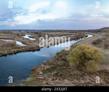 Panorama der Luftkurve mit Bäumen am Fluss mit bewölktem Himmel in der Ukraine Stockfoto