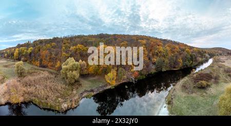 Luftbäume wachsen am Flussufer, Panorama mit Herbstwald und landschaftlich bewölktem Himmel in der Ukraine Stockfoto
