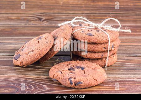 Blick auf Haferflockenkekse mit Schokolade auf Holztisch, Nahaufnahme, selektiver Fokus. Hausgemachte Kekse auf einem alten Holztisch Stockfoto