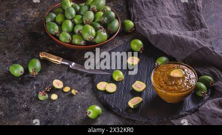 Tropische Früchte grüne reife Feijoa sellowiana Beeren und Marmelade daraus. Stillleben mit geschnittenen Feijoa-Früchten Stockfoto