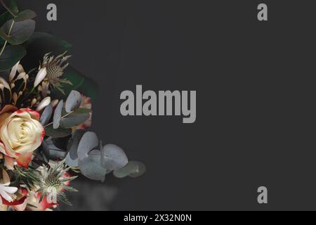 Blumenstrauß mit Rosen, Disteln und Eukalyptus auf schwarzem Hintergrund Stockfoto