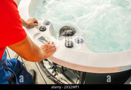 Kaukasischer professioneller SPA-Techniker, der die Reparatur des Wannen-Whirlpools durchführt Stockfoto